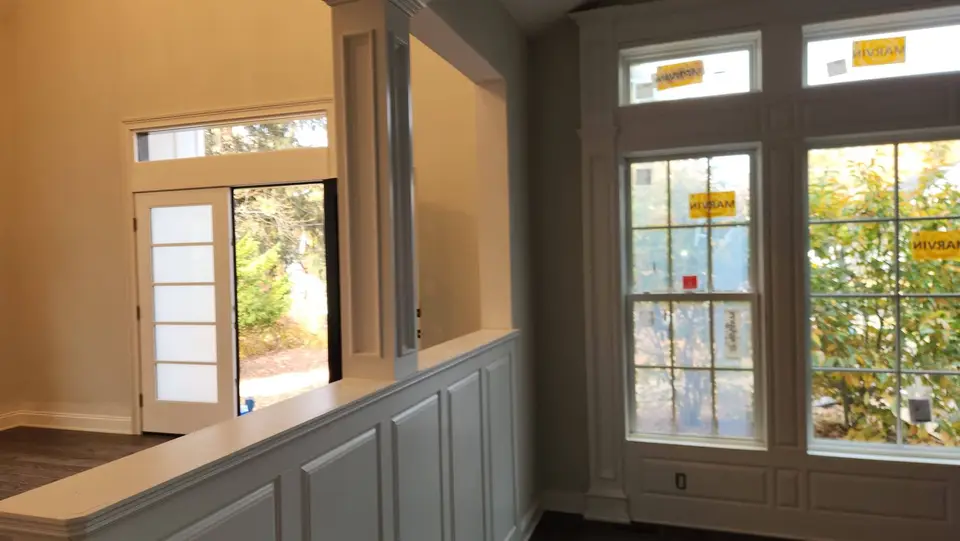 Room with painted wainscoting, glass door and tall windows